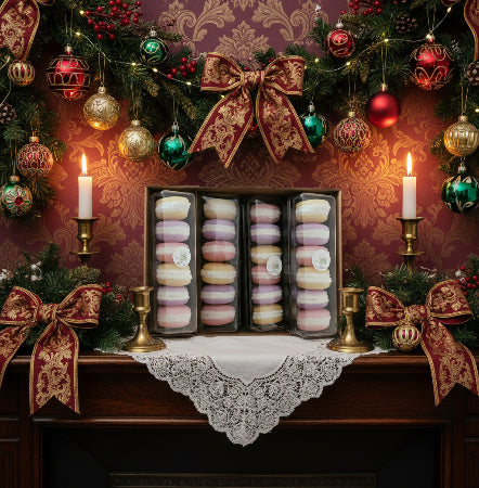 Decorative Christmas setting with a box of macarons on a tablecloth, surrounded by ornaments and candles.
