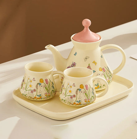 Ceramic tea set with floral designs on a tray against a neutral background
