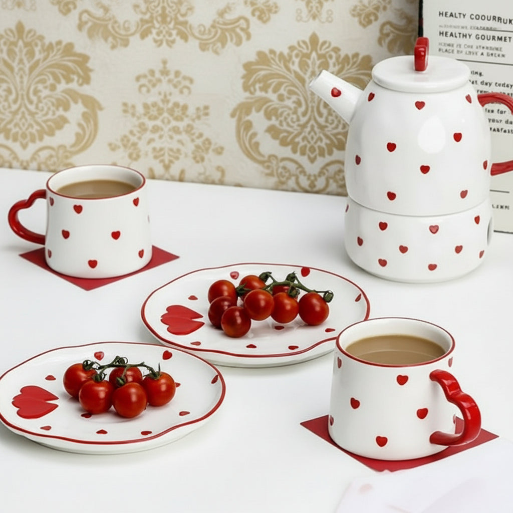 Ceramic tea set with heart patterns on a white surface