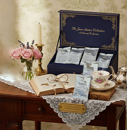 Tea set with 'Jane Austen Collection' on a decorative table with flowers and an open book.