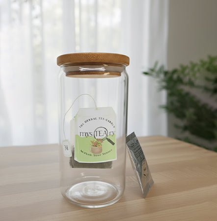Glass jar with wooden lid and tea bag on a wooden surface